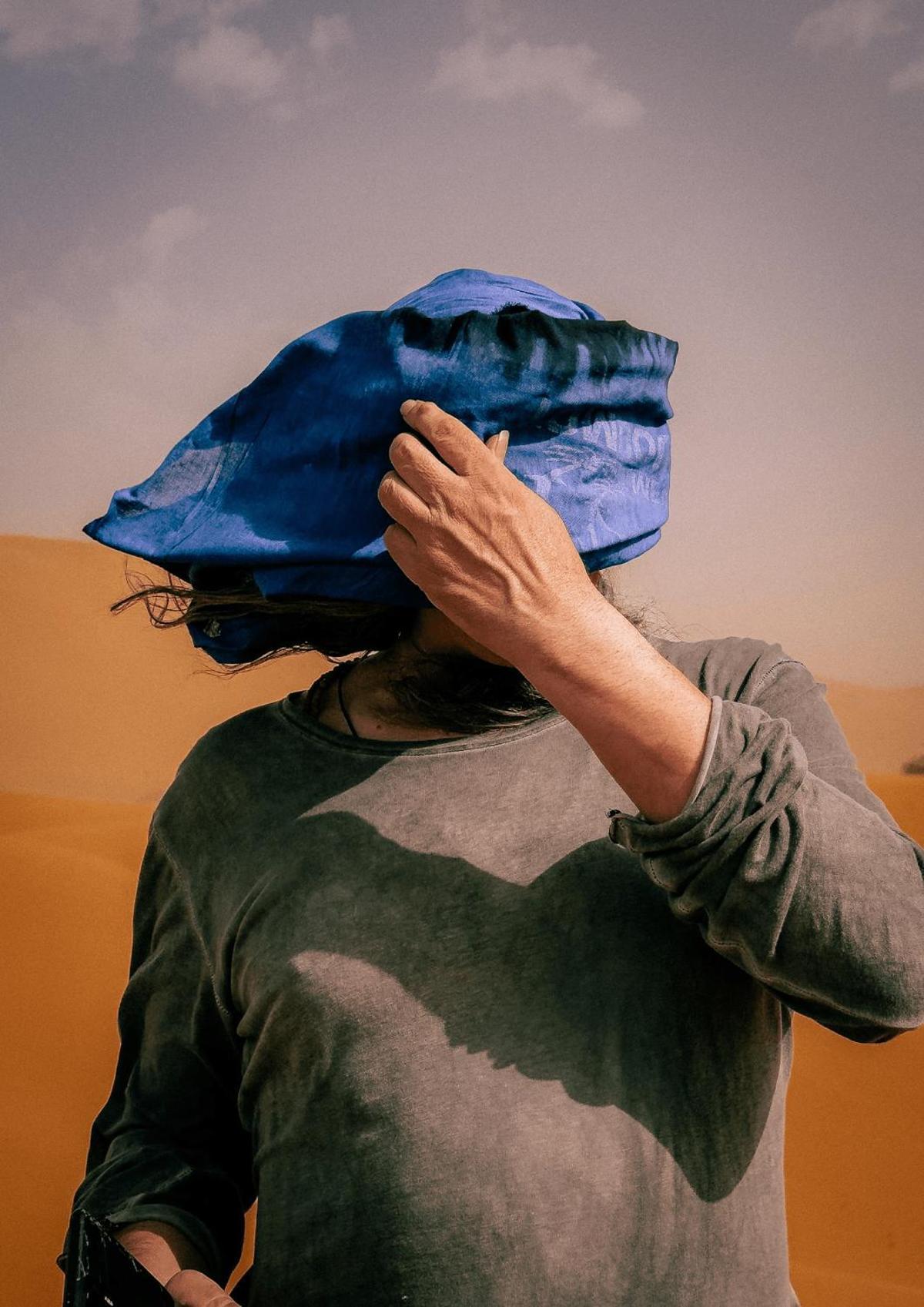 Erg Chebbi, Marruecos. Un viajero se cubre el rostro con un turbante azul en plena tormenta de arena, en el mismo desierto donde los nómadas llevan siglos usando esa prenda como protección. (iPhone 16 Pro Max)