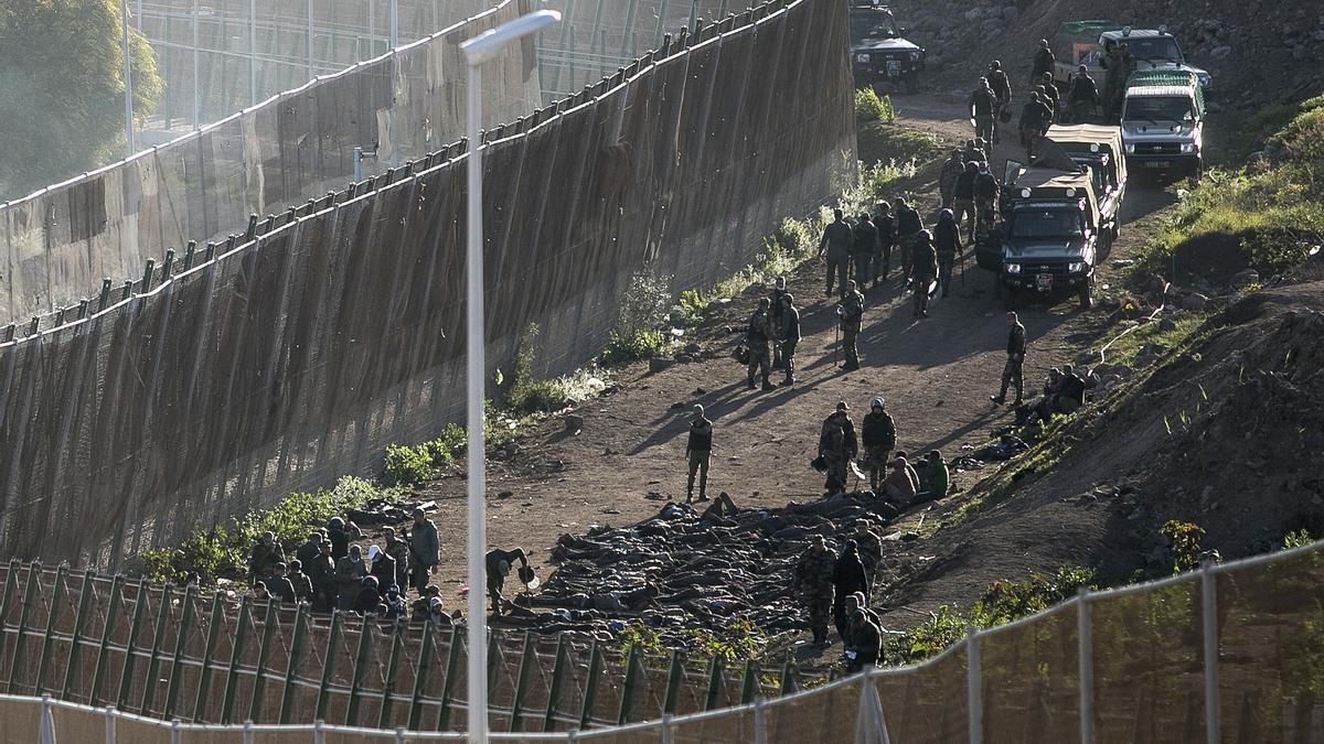 Europas Südgrenze: Sicherheitskräfte auf der marokkanischen Seite der Grenze zwingen Migranten, sich vor den Zaun zu legen, nachdem sie sie daran gehindert haben, die Zäune zwischen der spanischen autonomen Stadt Melilla in Nordafrika und Marokko zu überwinden.