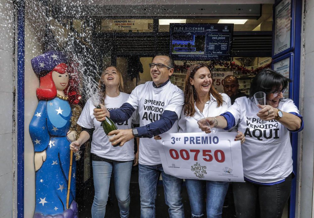 Trabajadores de la administración de la Avenida del Puerto, 173 en Valencia, celebran en su local que han distribuido parte del tercer premio del Sorteo Extraordinario de la Lotería de Navidad.