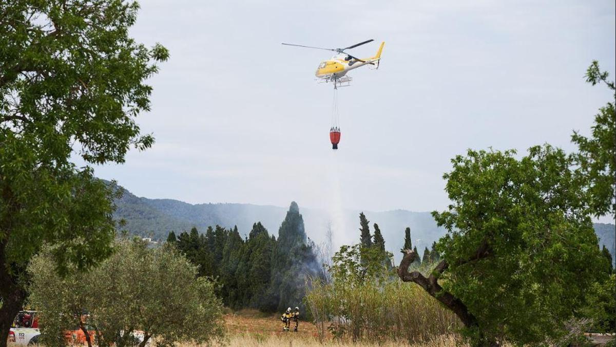 Un helicóptero hace una descarga sobre las llamas