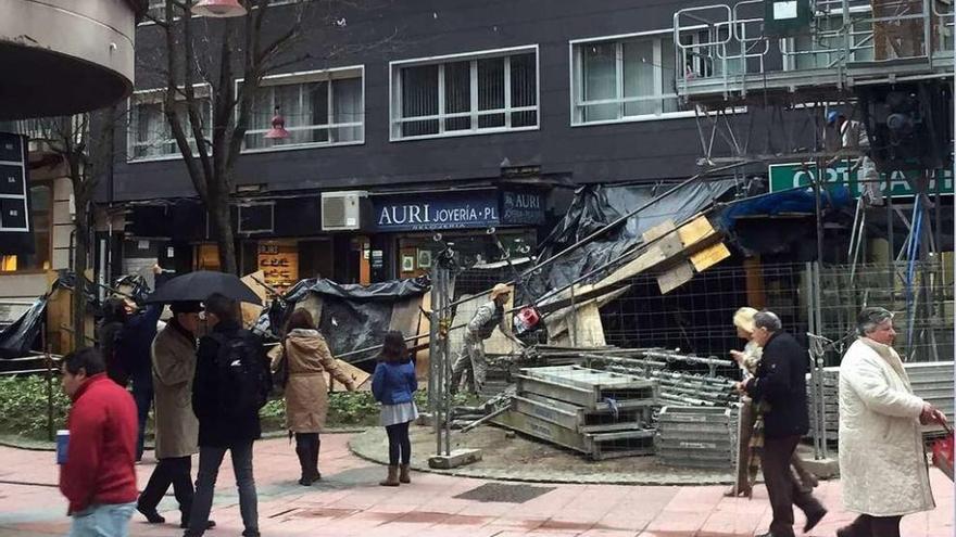 Varios peatones observan el andamio desplomado sobre la acera. // Rafa Vázquez