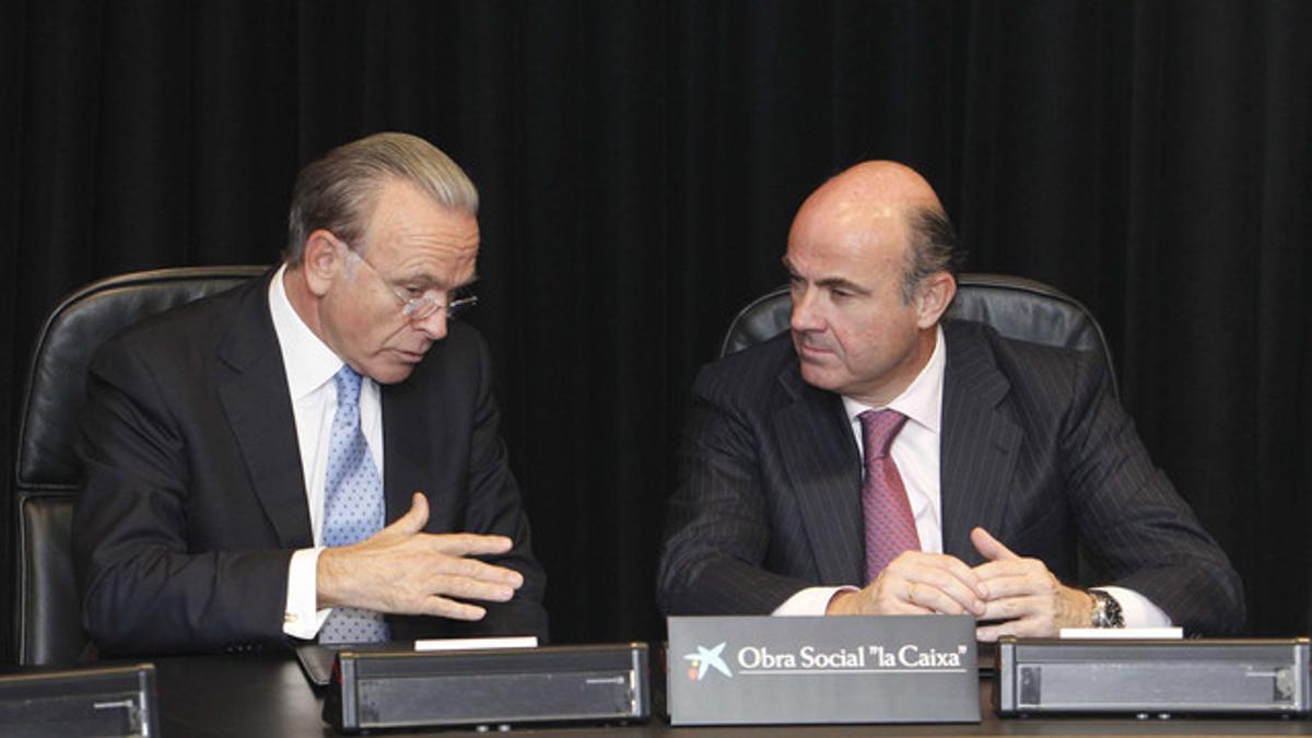 El presidente de La Caixa, Isidre Fainé, y el ministro de Economía, Luis de Guindos, el pasado octubre, durante la firma de un convenio sobre un nuevo programa de becas.