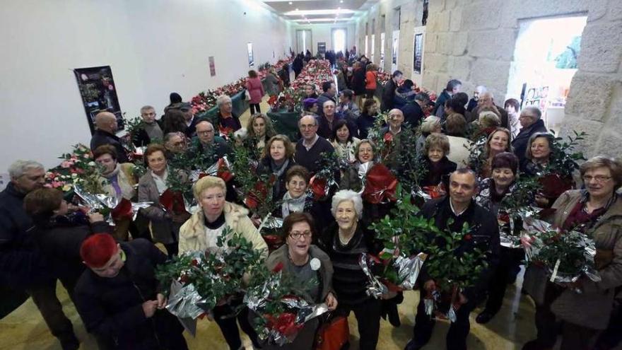 Expositores con las plantas recibidas como obsequio y primeros visitantes a la Mostra, en Tui. // A. Hernández