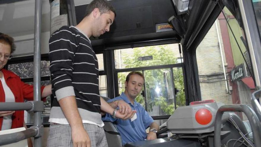 Un joven abona el billete del autobús urbano en Mieres.