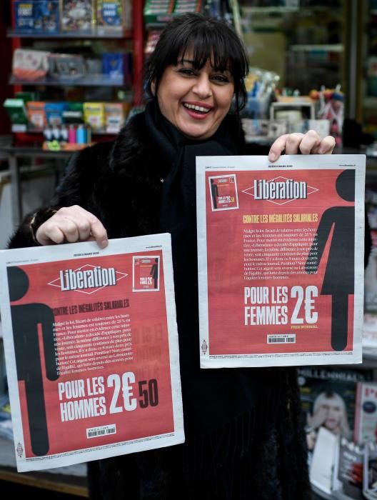 Una mujer sostiene dos carteles reivindicativos en París.