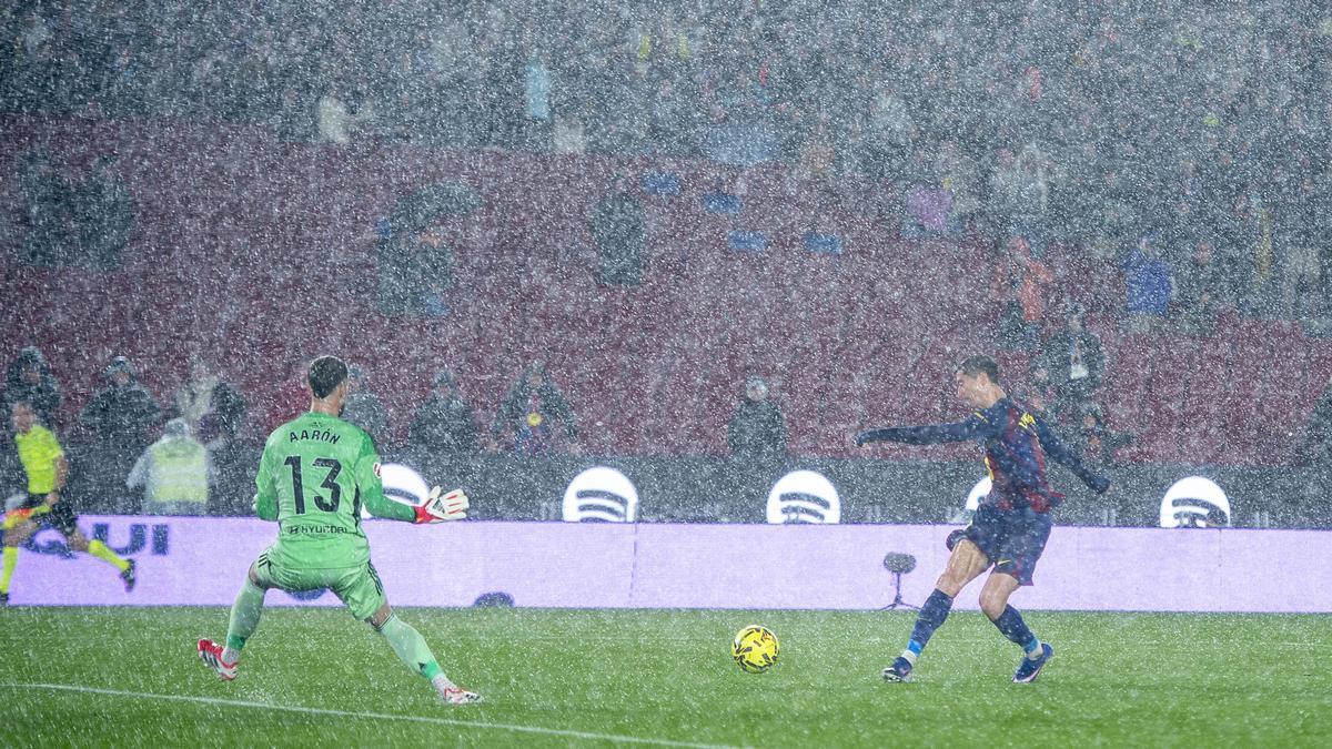 Lewandowski remata ante Aaron sin fortuna bajo un manto de granizo durante el partido de liga entre el FC Barcelona y el Real Oviedo en el Camp Nou