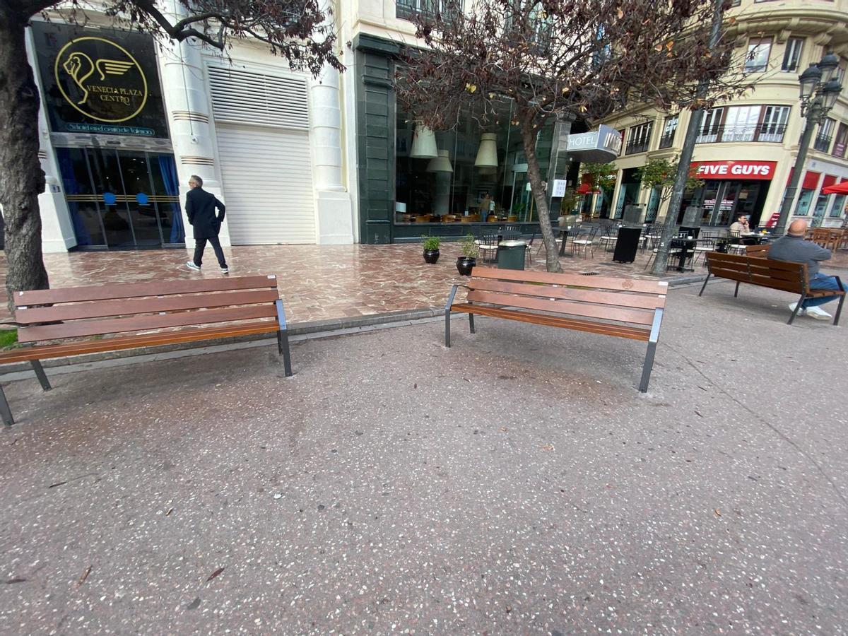 Bancs pintats de marró en la plaça de l’Ajuntament
