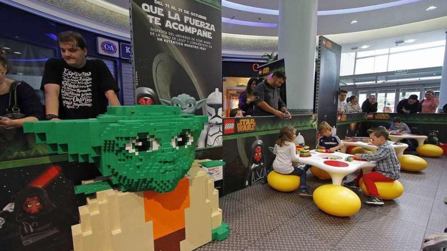 Varios niños juegan, ayer, en el espacio Lego. En primer término, una figura del maestro Yoda. // J. Santomé