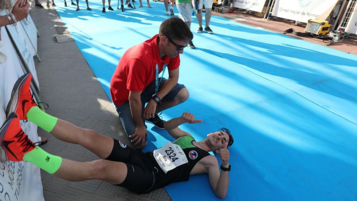 Borja Rodríguez de la Asociación Atlética de Móstoles, ganador de la prueba, es atendido por un sanitario al cruzar la meta. 