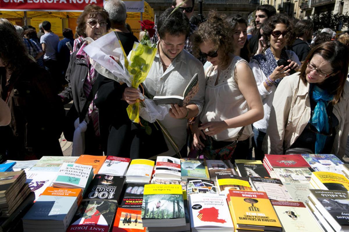 Una parella s’atura en una parada de llibres a Barcelona durant la diada de Sant Jordi.