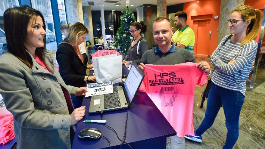 Varios participantes retiran su camiseta, dorsal y chip de la San Silvestre en el Hospital Perpetuo Socorro, ayer.