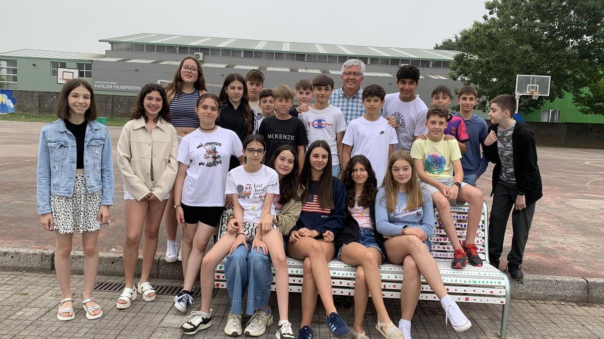El maestro, sonriente junto a sus estudiantes en su última foto con la clase.