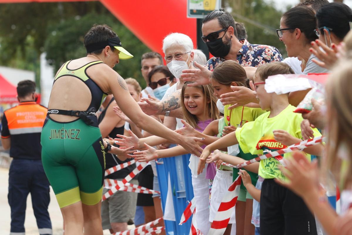 Una participantes saluda al público asistente al triatlón maleno.