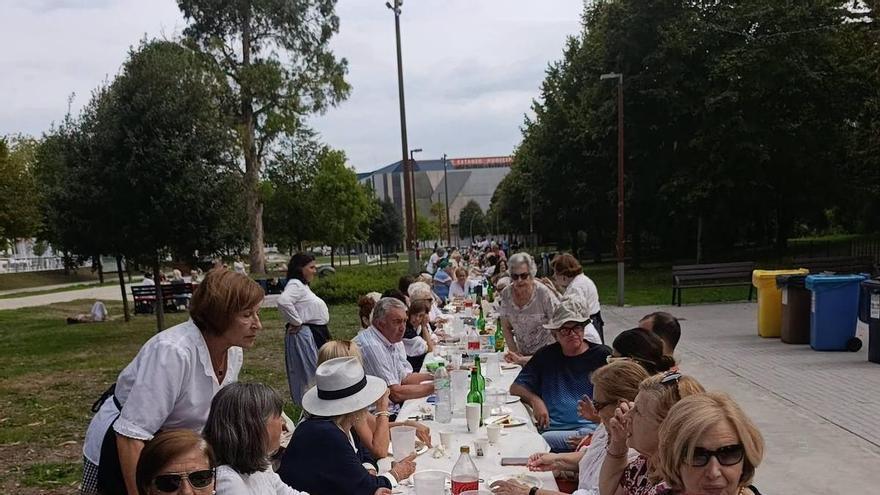 El barrio gijonés de La Arena se sienta a la mesa en la avenida del Molinón en su primera comida popular