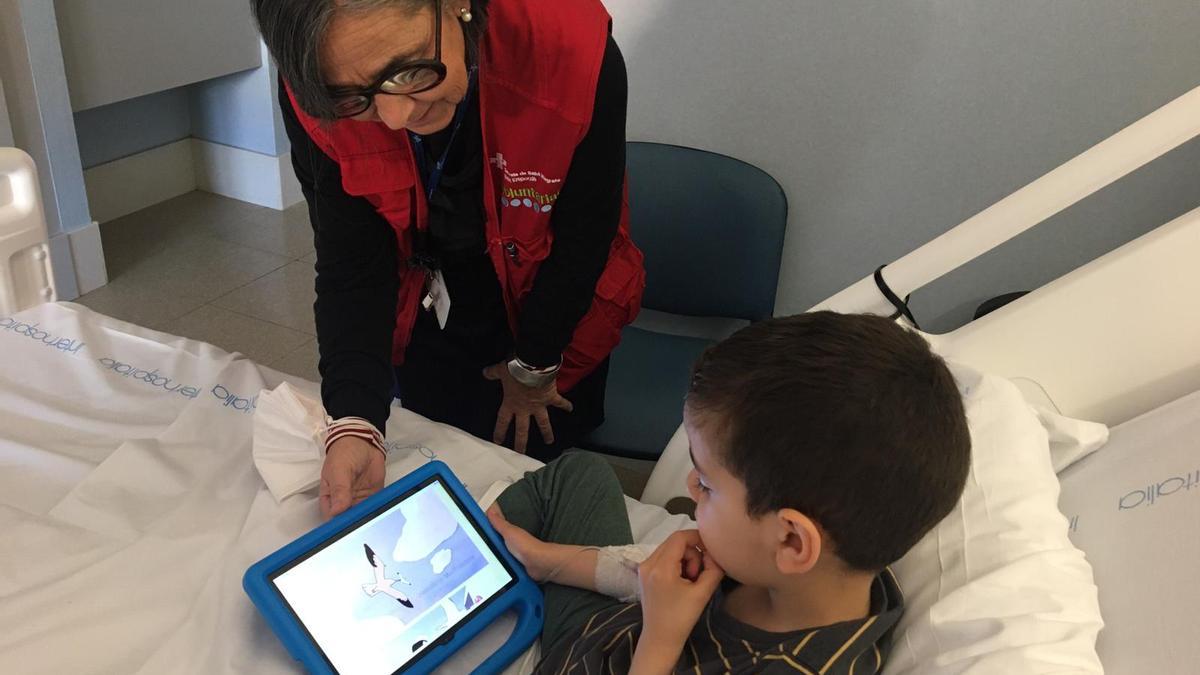 Un nen ingressat a l'hospital mirant contingut de la plataforma.