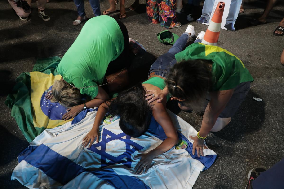 -FOTODELDÍA- AME9407. RÍO DE JANEIRO (BRASIL), 30/10/2022.- Simpatizantes del candidato Jair Bolsonaro se lamentan mientras se realiza el conteo de votos en la segunda ronda de las elecciones presidenciales, hoy, en Río de Janeiro (Brasil). El exmandatario Luiz Inácio Lula da Silva ganó este domingo la segunda vuelta de las elecciones presidenciales en Brasil con un 50,83 % frente al 49,17 % que obtuvo el actual gobernante, Jair Bolsonaro, con el 98,81 % de las urnas escrutadas. EFE/ Andre Coelho