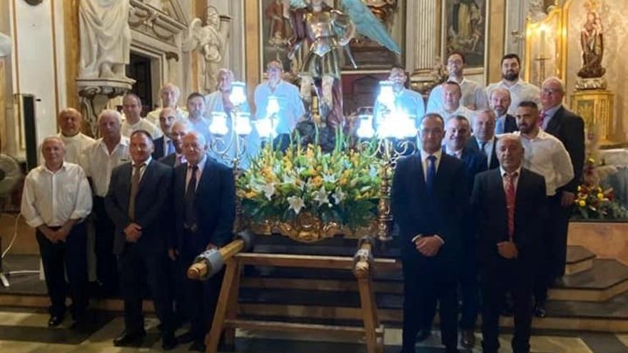 Los clavarios de San Miguel y sus costaleros delante del altar.