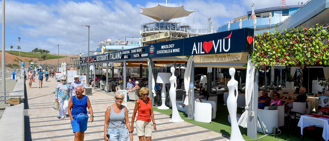 Turistas pasean junto a la zona comercial de Meloneras.