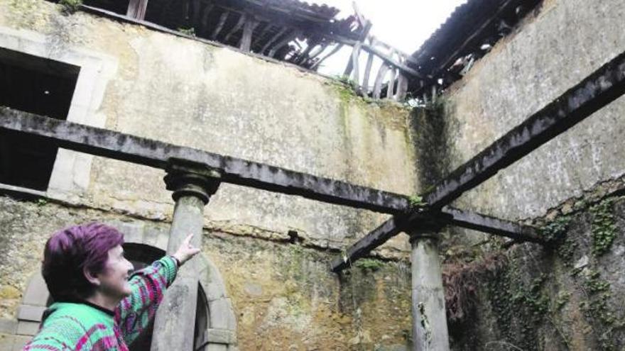 Pilar Fernández señala desde el patio el techo hundido de la esquina sudeste del palacio de Celles.