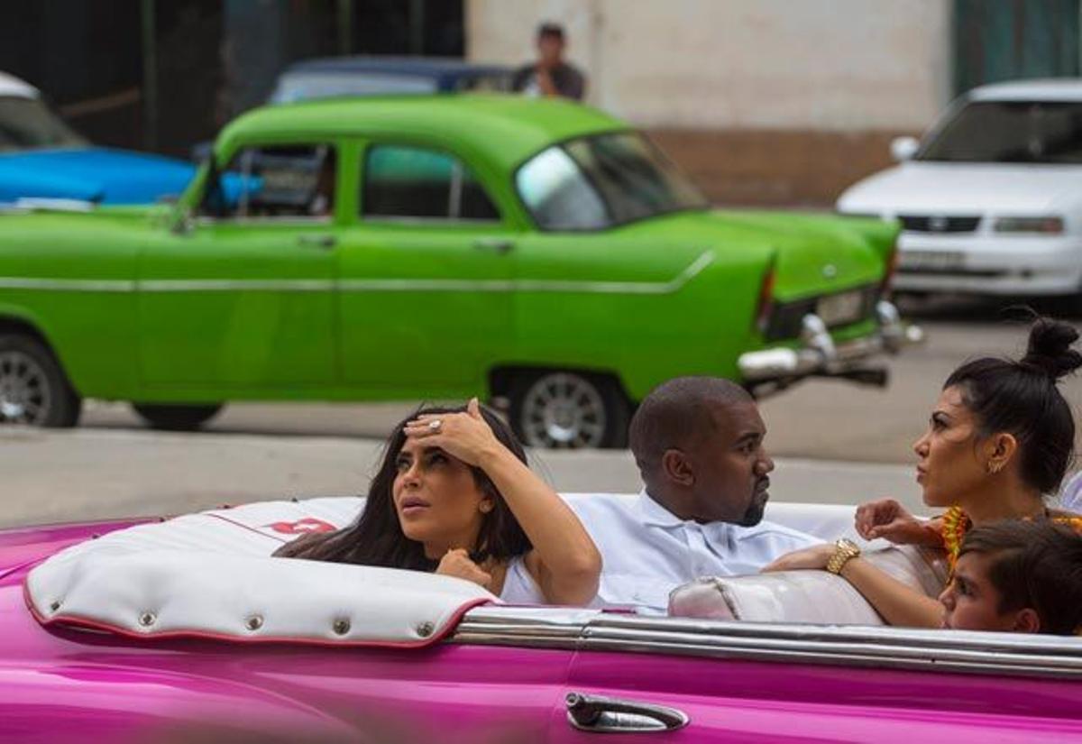 Kim y Kourtney Kardashian miran algo desde el descapotable fucsia en el que fueron haciendo turismo por La Habana