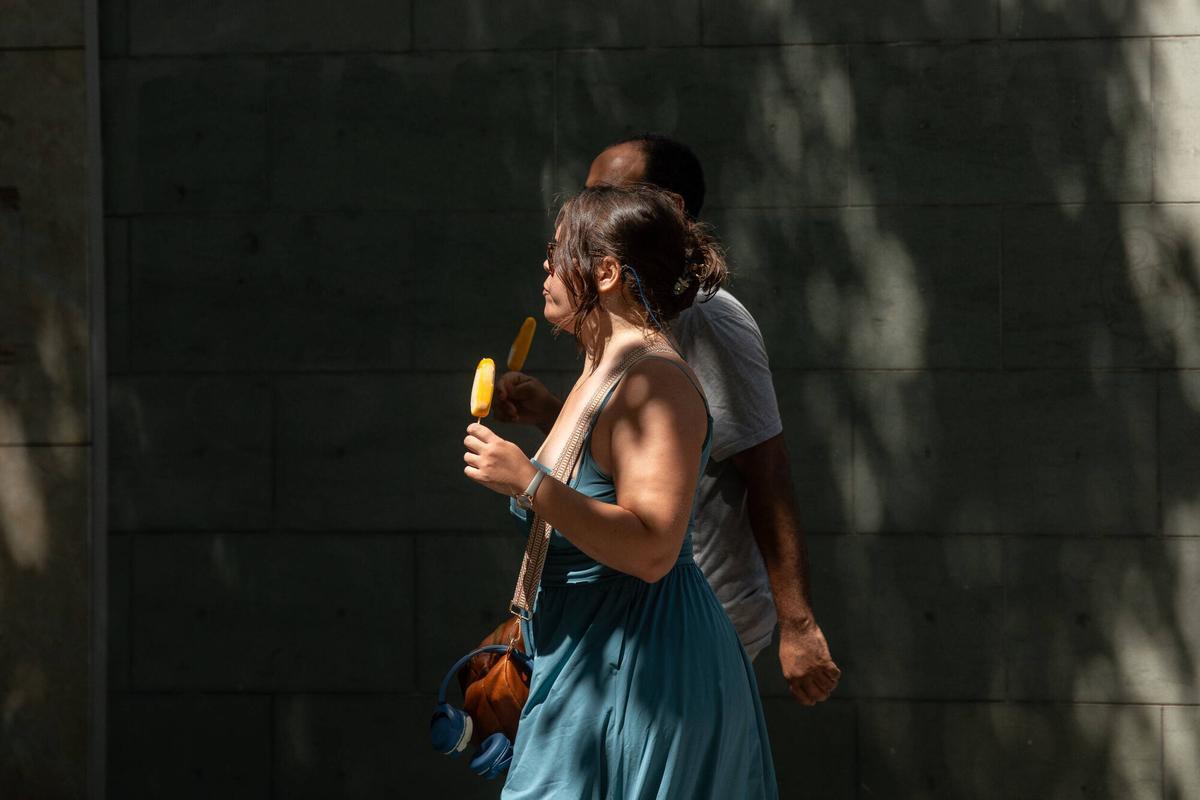 Una pareja come helados para refrescarse.