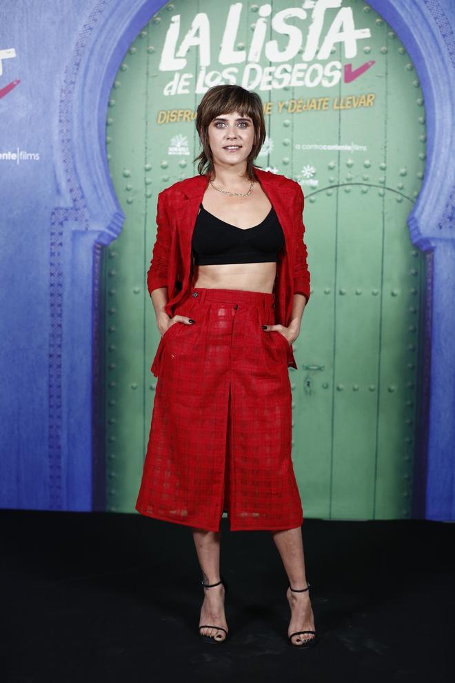 María León con traje rojo de americana y falda midi con crop top negro