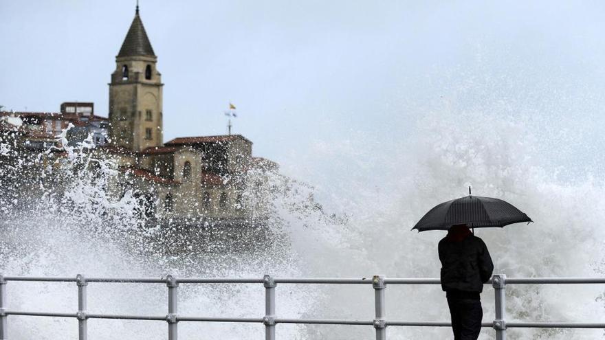 Lluvia y oleaje en el paseo marítimo de Gijón