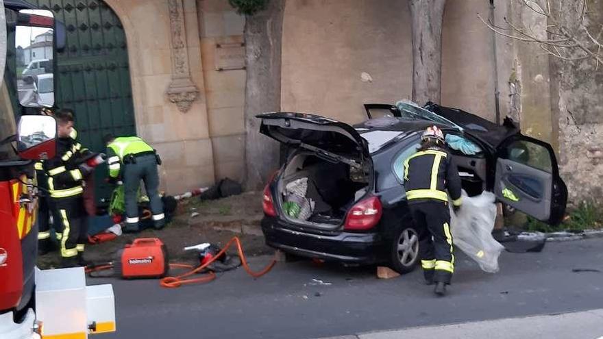 El vehículo, destrozado tras colisionar contra un muro de contención en Granda.