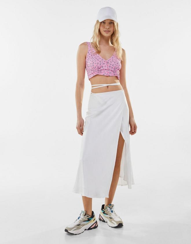 La modelo de Bershka se apunta al 'flossing' con la falda blanca midi con tiras en la cintura