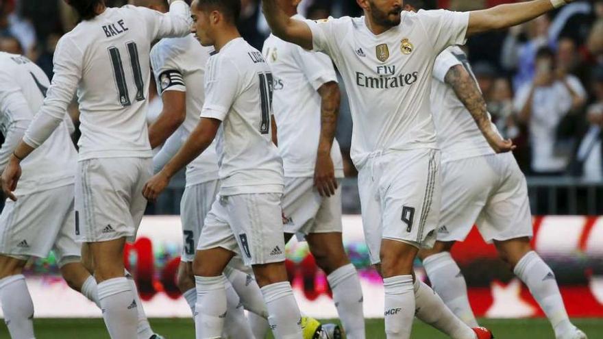 El francés Benzema celebra, rodeado de jugadores blancos, uno de los cuatro goles marcados ayer al Getafe en el Bernabéu. /Reuters