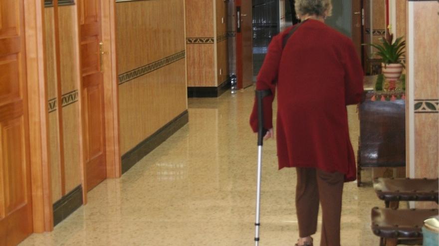 Una mujer mayor se ayuda de una muleta para caminar.