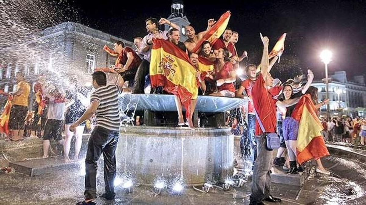 Aficionats espanyols celebren la victòria d’Espanya contra Alemanya a la Puerta del Sol, a Madrid.