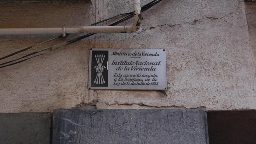 Placa amb el jou i les fletxes a un edifici del carrer dels Valls de Ripoll · J.R.