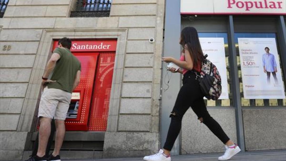 Una oficina del Santander, junto a otra del Popular, en Madrid.