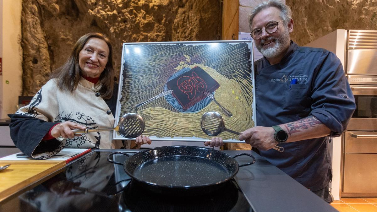 María Dolores Mulá y Jaime Seva, con una de las obras de la artista ante los fogones del Hestia Lucentum.