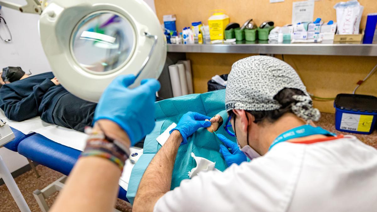 Un sanitario realiza una cirugía menor.