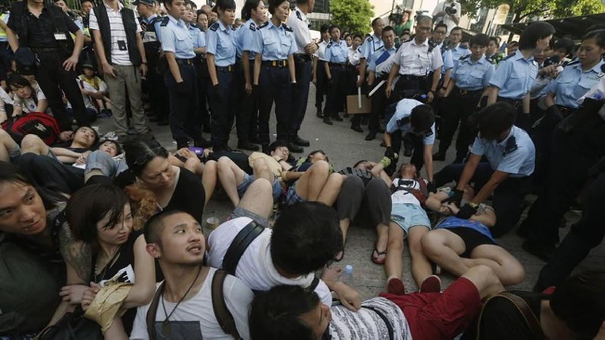 Participantes en la sentada unen sus manos para evitar ser detenidos, este miércoles en Hong Kong.