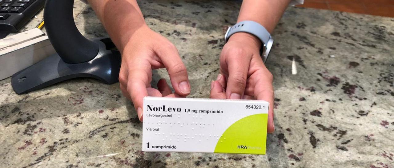 Una farmacéutica sostiene la caja de una píldora del día después.