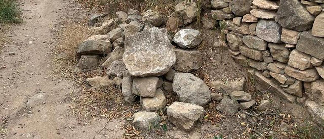 El mur amb les pedres despreses al terra