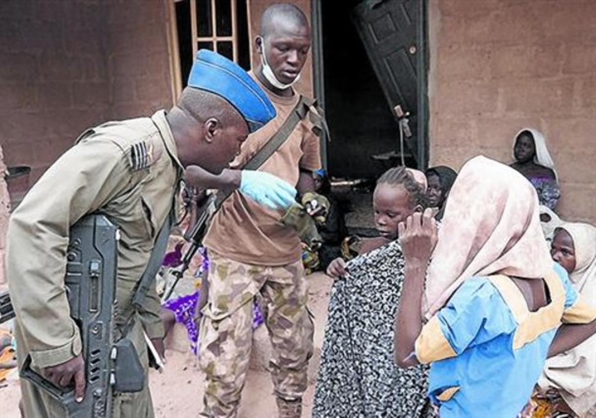 Un soldat nigerià amb algunes de les noies rescatades de les mans de Boko Haram.