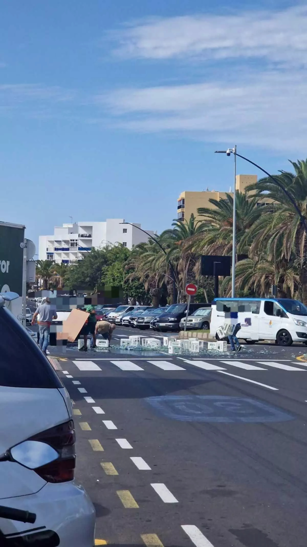 Un camión 'hace aguas' en Tenerife: pierde su carga y llena la vía de botellas rotas