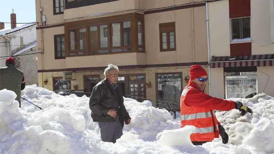 Un miembro de Cruz Roja abre paso en la nieve a un vecino de Barruelo.