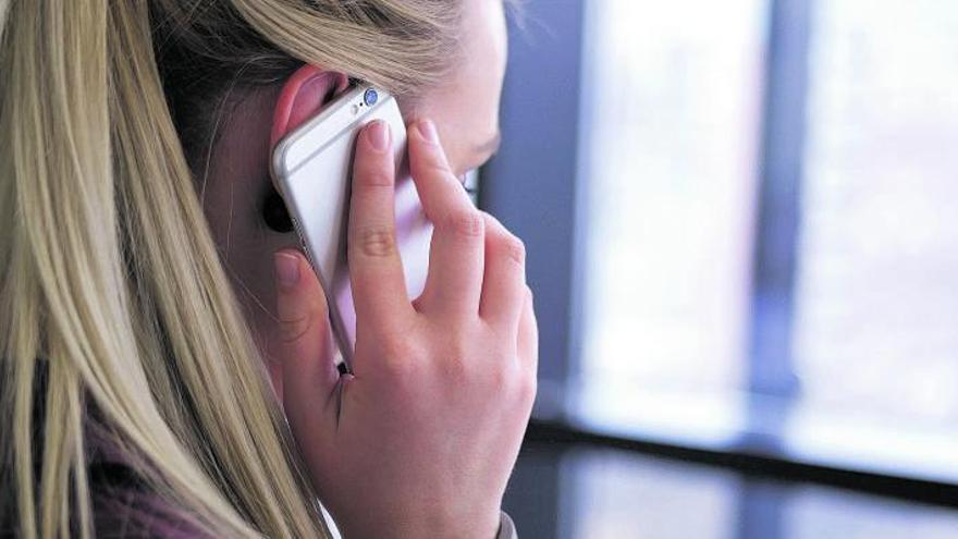 Una mujer realiza una llamada a través de su teléfono móvil.