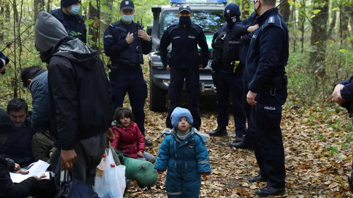 Una familia iraquí rodeada por la policía polaca en la frontera entre Polonia y Bielorrusia.