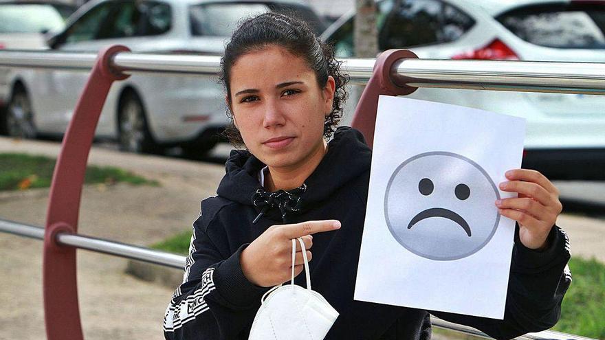 Judith Pedreira, ayer con la mascarilla y un papel con un emoticono con gesto serio.