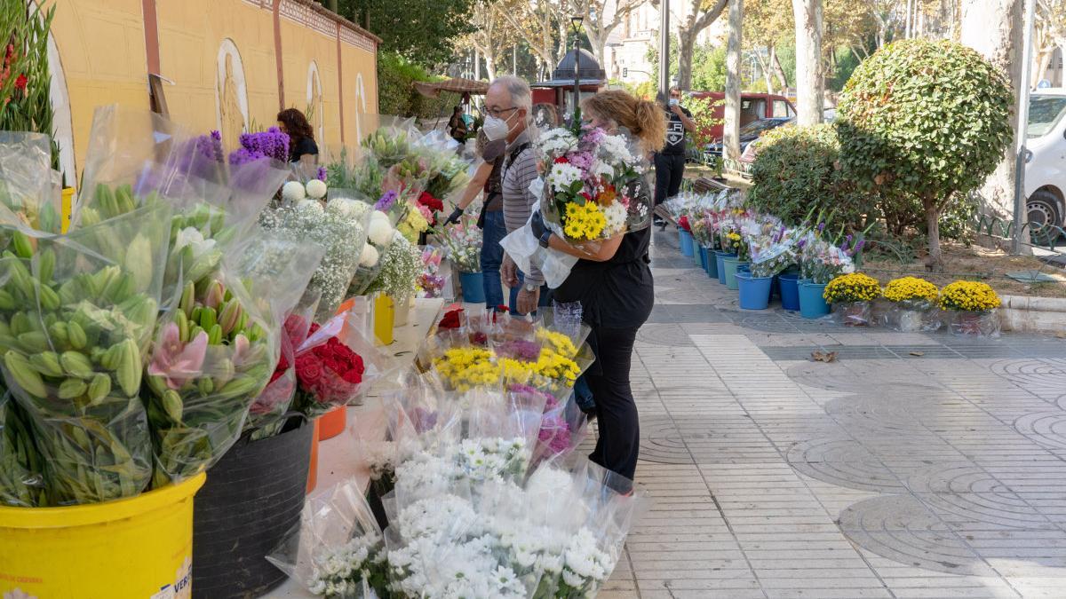 Usuarios compran flores en el mercadillo de Todos los Santos.