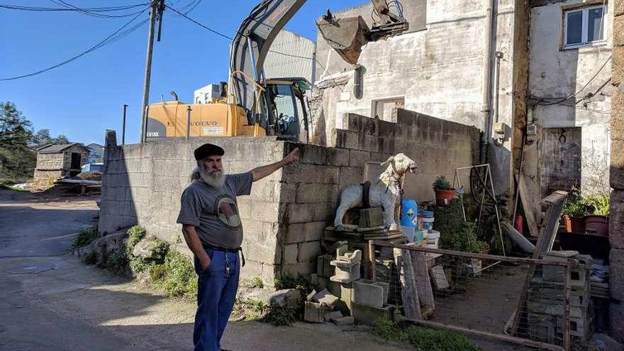 Isolino Bardanca señala su casa, con la excavadora detrás.