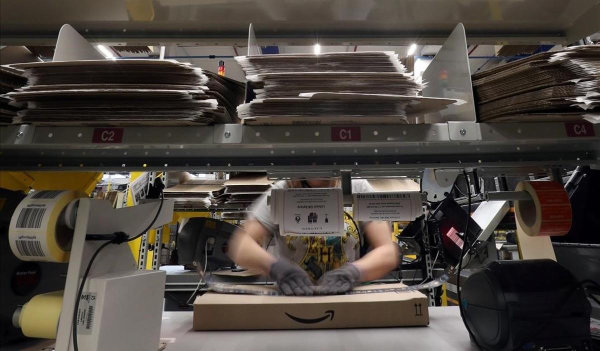 zentauroepp42522608 a worker packages an order at amazon distribution center in 180706110158