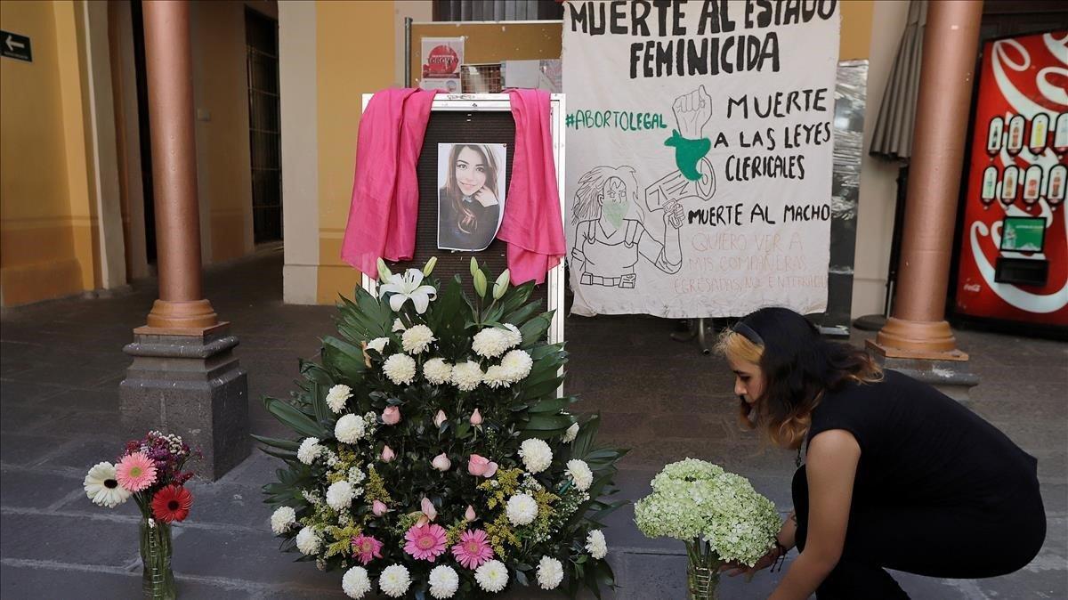 zentauroepp52269750 a woman places flowers to pay tribute after the gruesome mur200213134234
