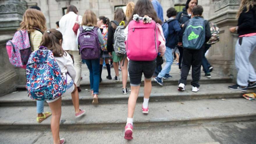 Varios niños a la entrada de su colegio.